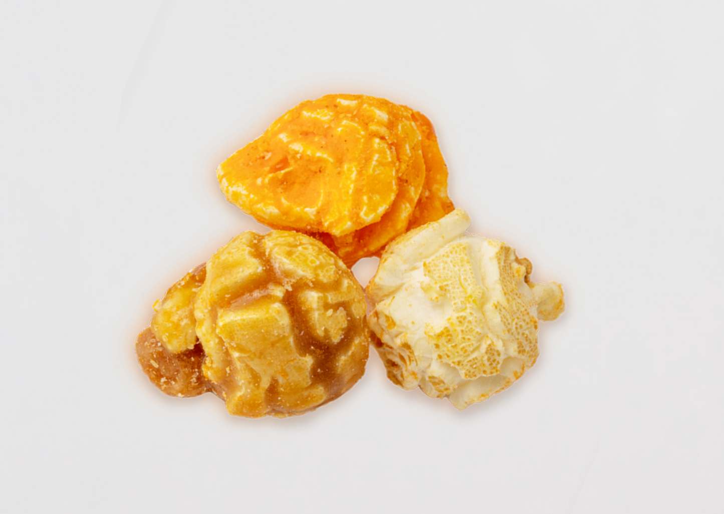 Three flavors of popped popcorn kernels stacked in a pile.