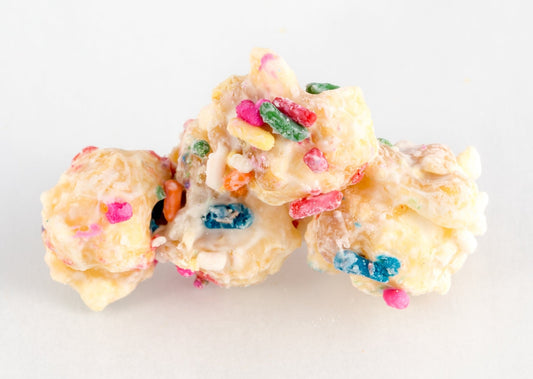Four chocolate-coated popped popcorn kernels with sprinkles.