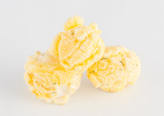 Three pieces of white-cheddar coated popped popcorn kernels.