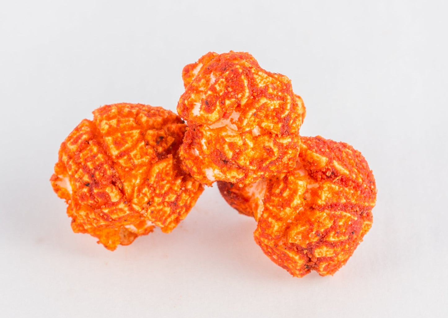 Three pieces of cheese-covered popped popcorn kernels.