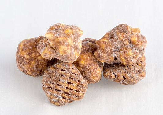 Four pieces of popped popcorn kernels and rice cereal covered in chocolate and peanut butter.