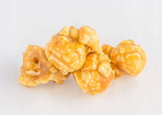 A stack of four caramel-coated popped popcorn kernels.