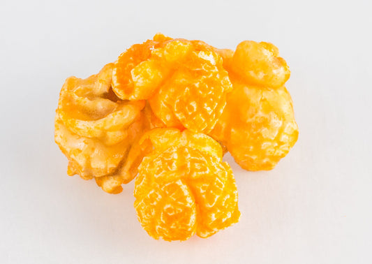 A stack of four pieces of popped popcorn kernels. Two caramel-coated kernels and two cheese-coated kernels.