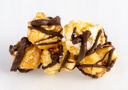 Five kernels of popped popcorn covered in caramel, chocolate, and salt.