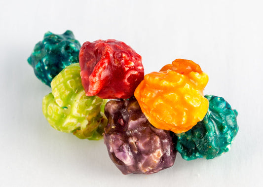 Multi-colored fruit flavored popped popcorn kernels.